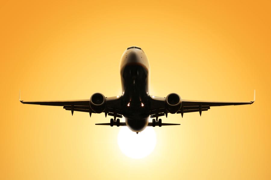 Flymaskine med solopgang i baggrunden
